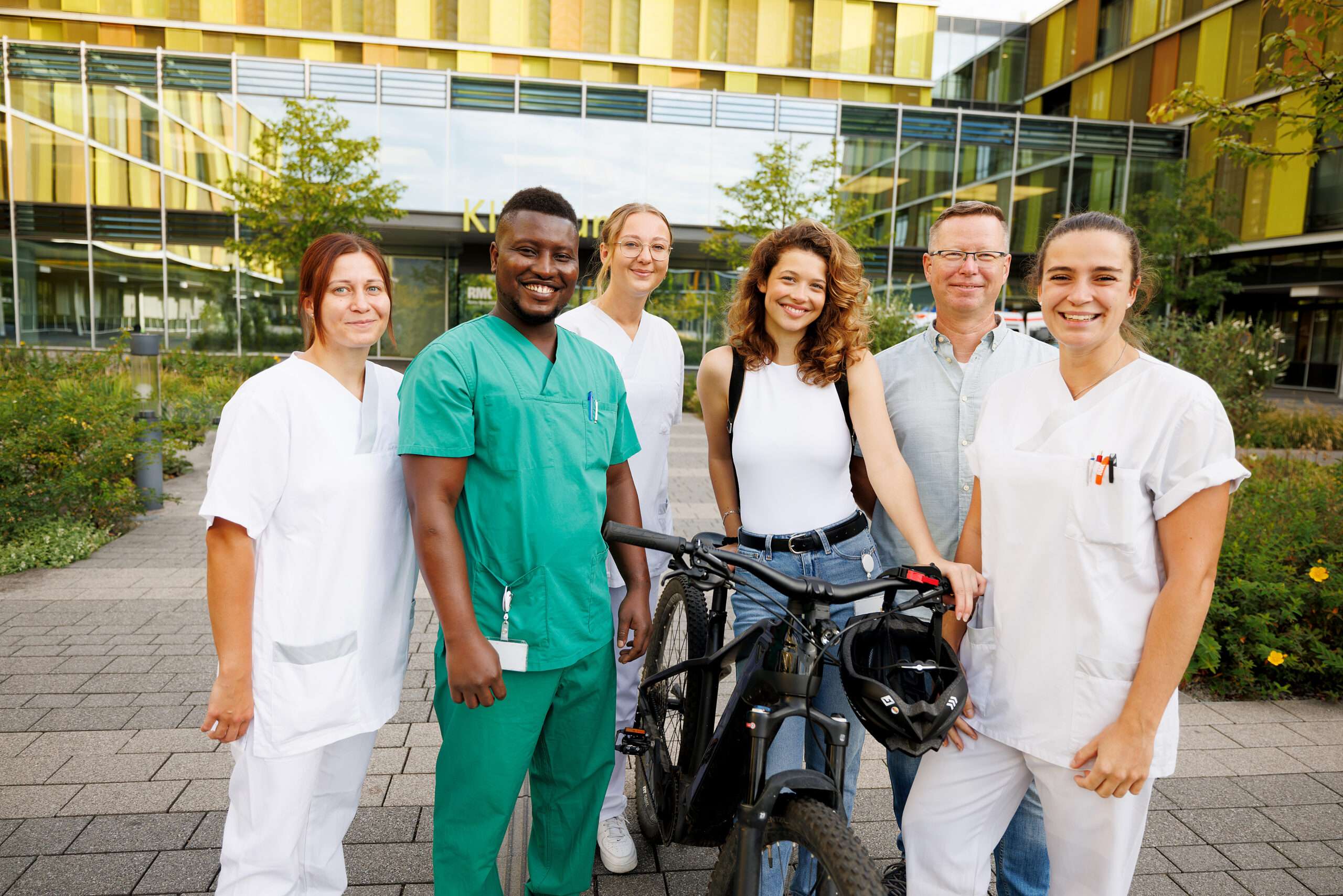 Kolleginnen aus der Pflege stehen zusammen vor dem Hauptgebäude des Klinikums Winnenden