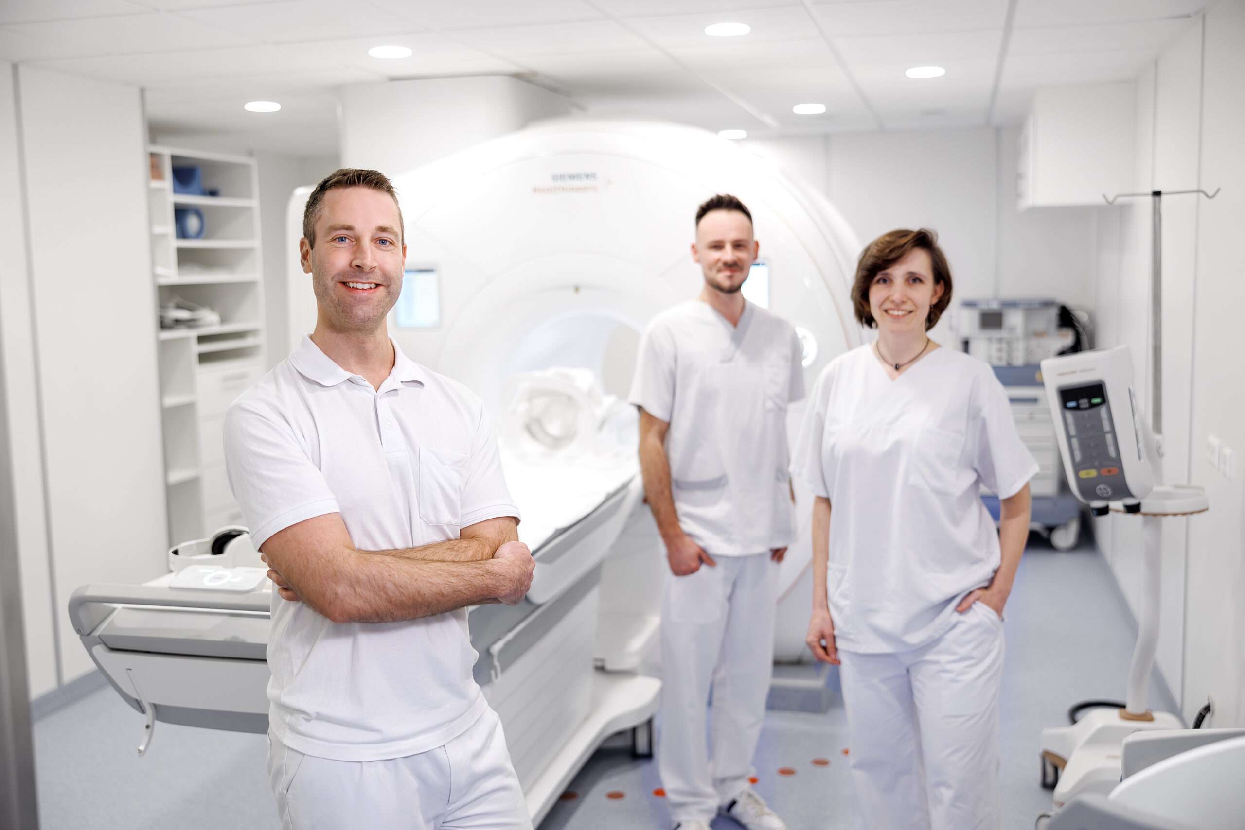 Leitender Oberarzt Dr. Wingert zusammen mit einer Kollegin und einem Kollegen aus der Radiologie vor dem MRT am Standort Schorndorf